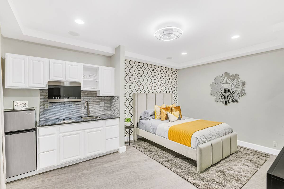 A modern bedroom with a bed, bedside table, and a decorative wall piece.
