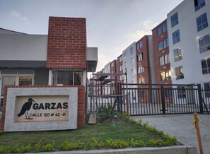Um edifício com uma placa que diz "GARZAS" e "Calle 120 # 42-41".
