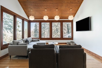 Large, light filled living room with high ceilings and mountain views