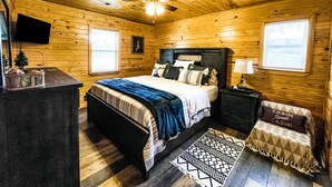 A wooden cabin bedroom with a bed, nightstand, and a ceiling fan. - Cabin #3 • 1 Mile to DeGray Lake (Bismarck)