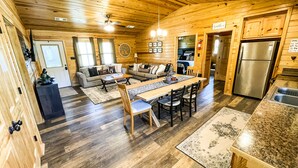 A spacious log cabin with a dining area, kitchen, and living room. - Cabin #3 • 1 Mile to DeGray Lake (Bismarck)