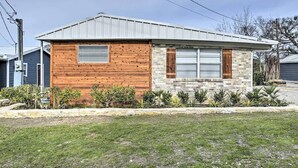 A single-story house with a gabled roof, a wooden front wall, and a stone facade. - Casa del Lago! Lakefront Retreat with Semi-Private Cove, Deck, and Firepit - Ideal for R&R! (Laguna Park)