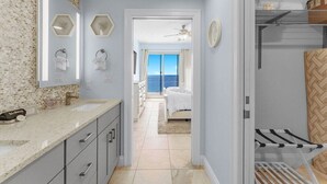 A modern bathroom with a large mirror, a sink, and a shower area. - Gulfcrest 19th-Floor | Beachfront | Huge Balcony (Panama City Beach)