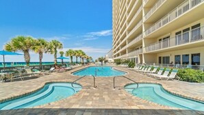A pool area with multiple swimming pools, lounge chairs, and palm trees. - Gulfcrest 19th-Floor | Beachfront | Huge Balcony (Panama City Beach)