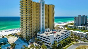 A high-rise hotel with multiple floors, a parking garage, and a beach view. - Gulfcrest 19th-Floor | Beachfront | Huge Balcony (Panama City Beach)