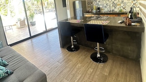 A modern kitchen with a central island, bar stools, and a ceiling fan. - At the best location and ocean view (Loreto)