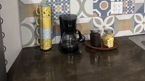 A kitchen counter with a coffee maker, a jar of honey, and a decorative item on the shelf. - At the best location and ocean view (Loreto)