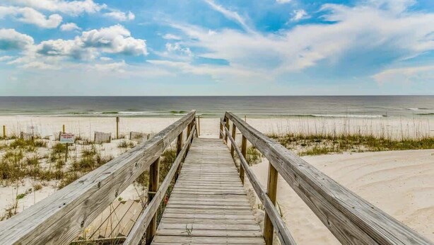 A wooden boardwalk leading to a beach with a clear sky. - Beachside Townhouse w/ Community Pool & Patio (Pensacola)