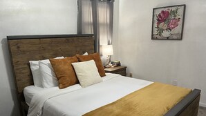 A neatly made bed with a wooden headboard, white bedding, and a mustard-colored throw blanket. - Cute 4 bed 2.5 bath Home - Sleeps 12! 30 night min (Virginia Beach)