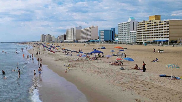 A beach with multiple hotel buildings in the background, sandy beach, and people enjoying the water. - Cute 4 bed 2.5 bath Home - Sleeps 12! 30 night min (Virginia Beach)