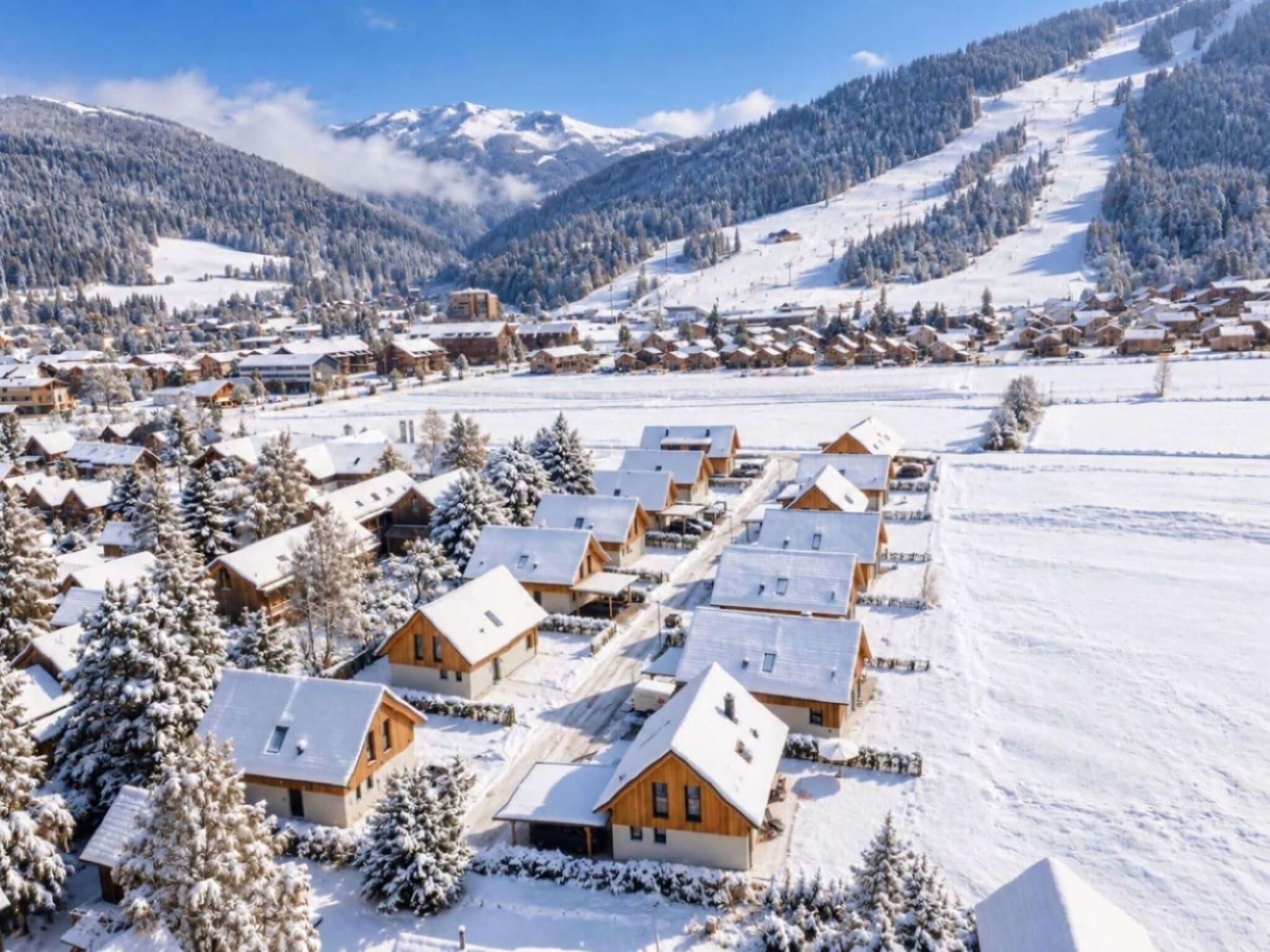 Un pueblo cubierto de nieve con casas de madera y una montaña al fondo.