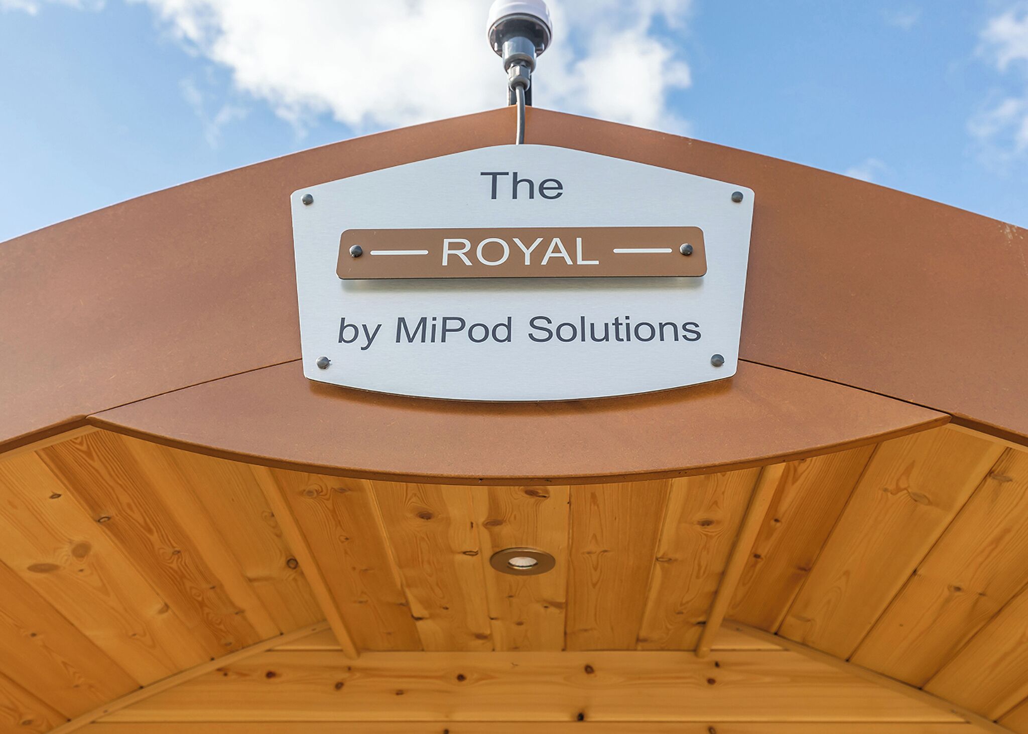 A sign with the text 'The ROYAL by MiPod Solutions' mounted on a structure with a wooden interior.
