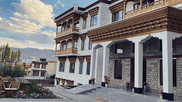 A multi-story building with traditional architectural elements, including balconies and decorative columns. - Hotel Barath Ladakh (Leh)