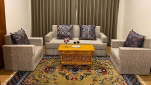 A living room with a sofa set, two armchairs, a coffee table, and a patterned rug. - Hotel Barath Ladakh (Leh)