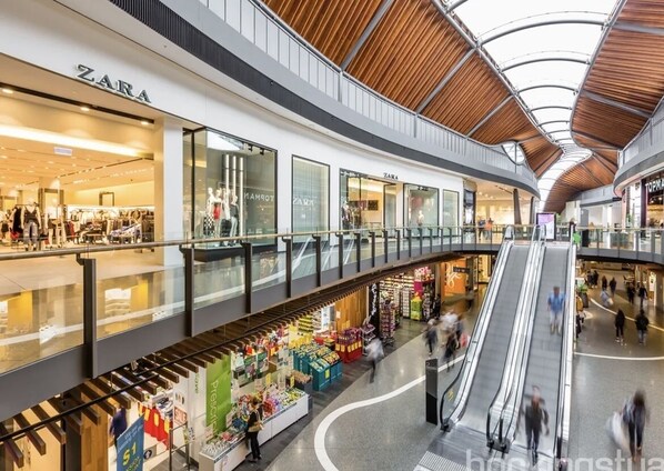Un centro comercial de varios niveles con Zara y otras tiendas.