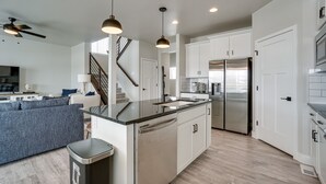 A modern kitchen with white cabinets, stainless steel appliances, and a central island. - Family-Friendly Townhome ~ 2 Mi to Windsor Lake! (Windsor)