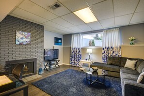 A living room with a fireplace, a television, a sofa, and a coffee table.