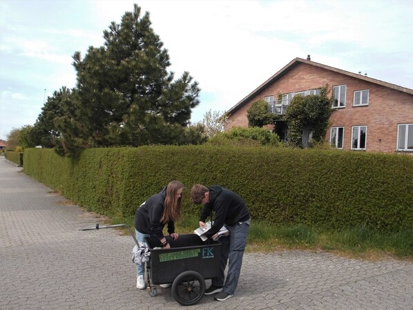 Twee personen laden een karretje, met een bord waarop staat: FOR UNGE DER VIL TAGES SERIÖSTI DISTRIBUTION.