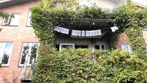 A building with ivy-covered walls and a balcony with string lights. - v. Limfjord, 3 km to Thisted, views, bikes, self-check-in possible  (Thisted)