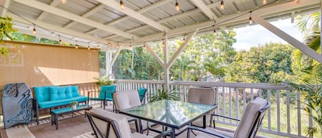 Relax in a serene outdoor space with a glass-top table and comfortable seating, surrounded by lush greenery and a soothing ambiance.