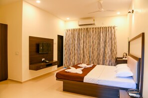 Relax in comfort with a large bed, flat-screen TV, and ceiling fan.