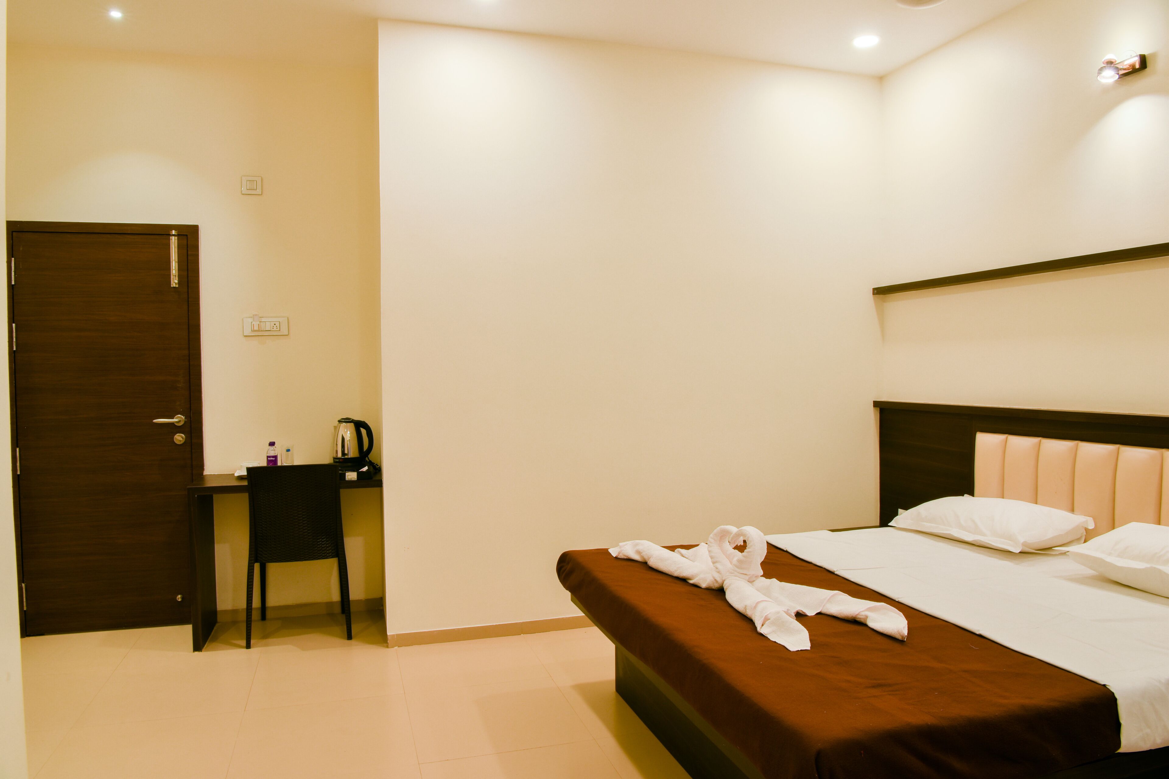 Una habitación de hotel con una cama, un escritorio y una silla.