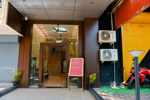 Enter a modern building with a clear view of the interior through the glass door, featuring a staircase leading to the upper floors.