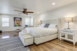 A bedroom with a large bed, a ceiling fan, a bedside table with a lamp, and a painting on the wall. - Spacious Surprise Home: Private Yard + Patio (Surprise)