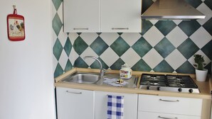 A kitchen with a sink, stove, and cabinets. - Apartment in old Building (Santa Cesarea Terme)