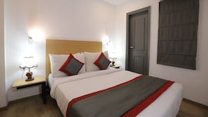 A hotel room with a bed, nightstands, and a window with curtains. - Qotel Hotel La Serene Gagan Vihar (New Delhi)
