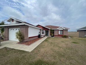 residence with a two-story house, well-manicured lawn, and a small garden.