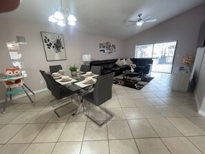 Relax in this stylish living space with a dining area for four, a comfortable sofa, and a high chair for kids.