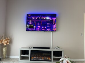 Cozy living room with a flat-screen TV, fireplace, and decorative touches.