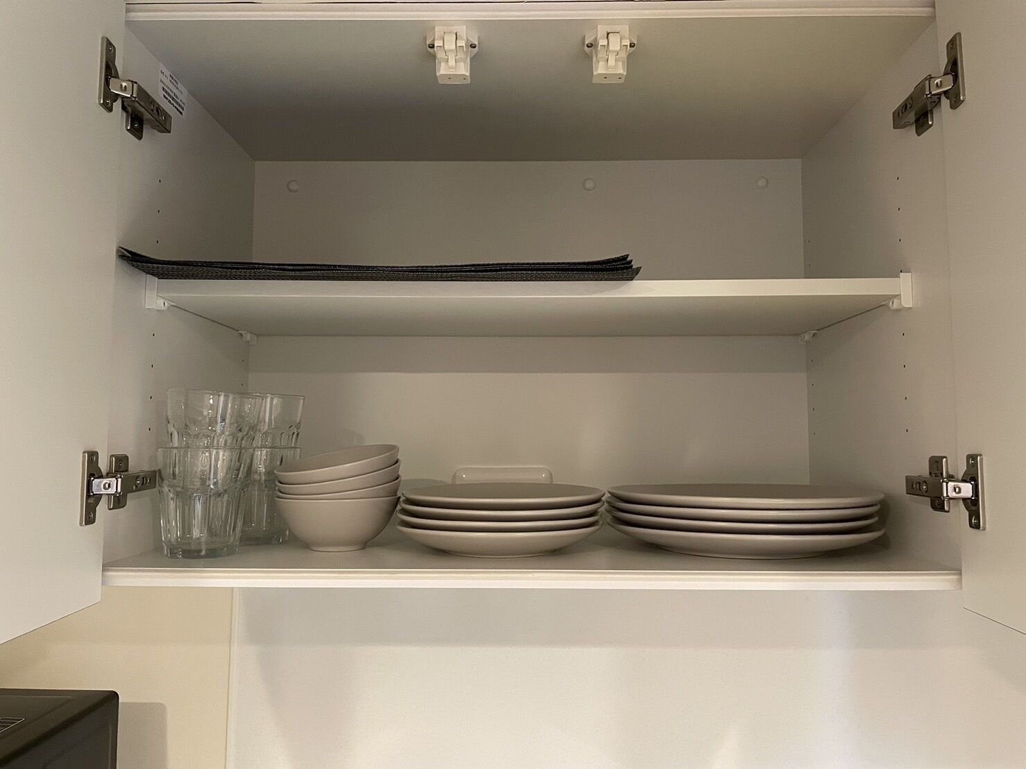 A kitchen with white cabinets, a black countertop, and a white sink.