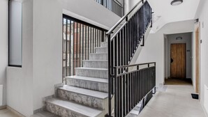 A modern staircase with marble steps and black railings, leading to a second floor. - Sanders Old Port - Precious 1-bdr. Apt. w/ Balcony (Thessaloniki)