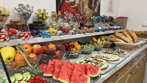 Un buffet proposant une variété de fruits, de légumes et de pâtisseries.