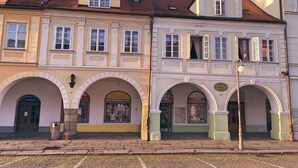 Une rangée de bâtiments européens traditionnels, dotés d’arcs au-dessus des fenêtres, bordant une rue pavée.