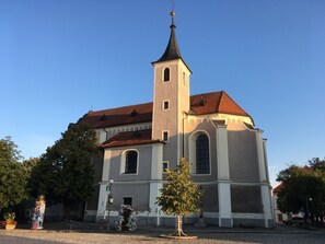 Eine Kirche mit hohem Turm und rotem Dach.