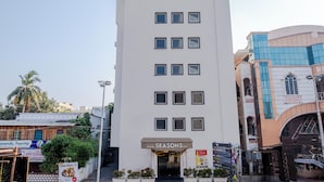 A hotel named Seasons Inn with a white facade, multiple windows, and a signboard.