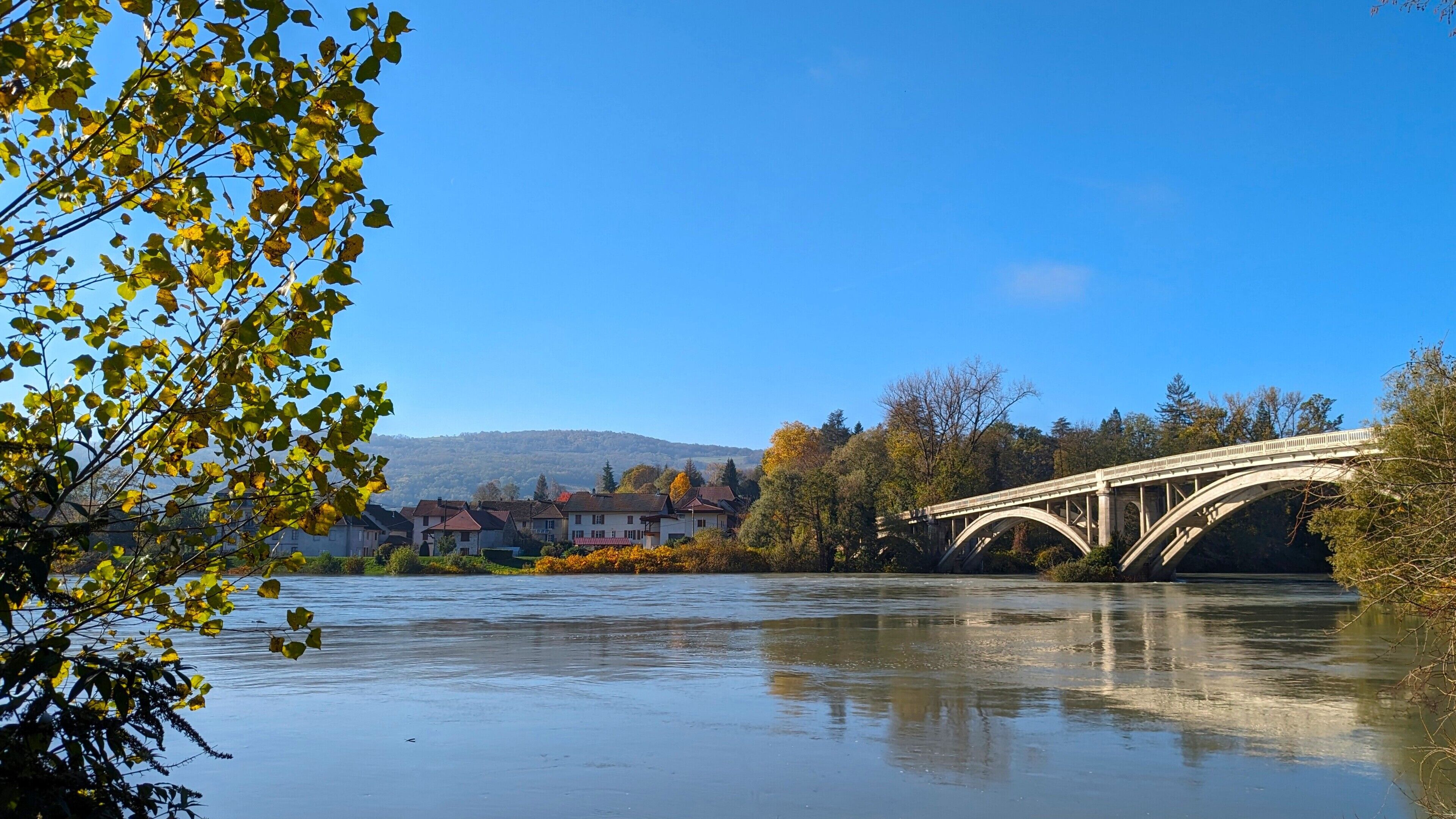 Eine Brücke über einem Fluss, im Hintergrund Häuser.