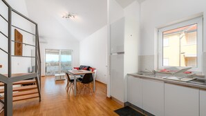 Een moderne keuken met witte kastjes, een roestvrijstalen spoelbak en een raam met uitzicht op de stad.