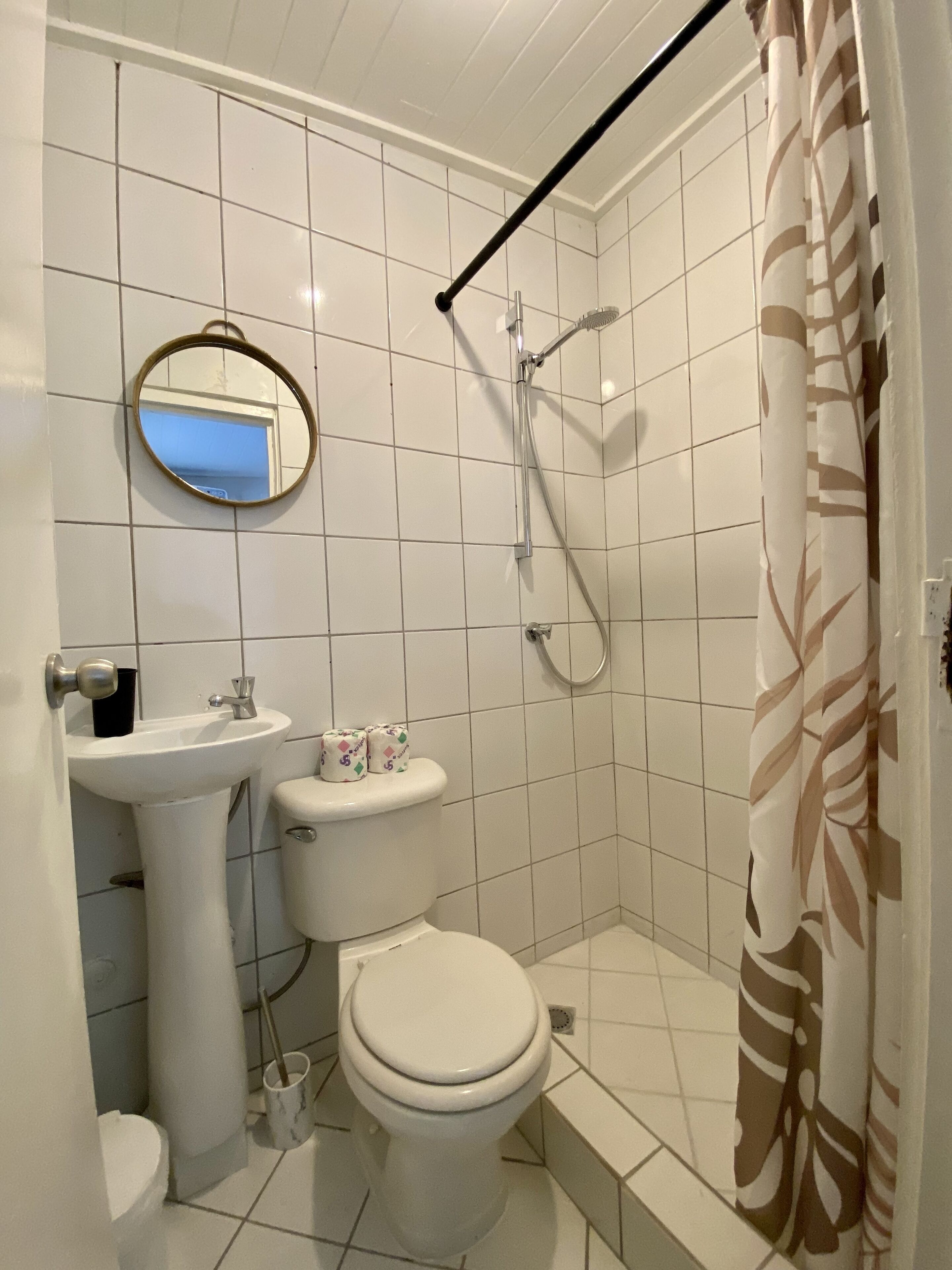 Une salle de bain comprenant des toilettes, un lavabo et une douche.