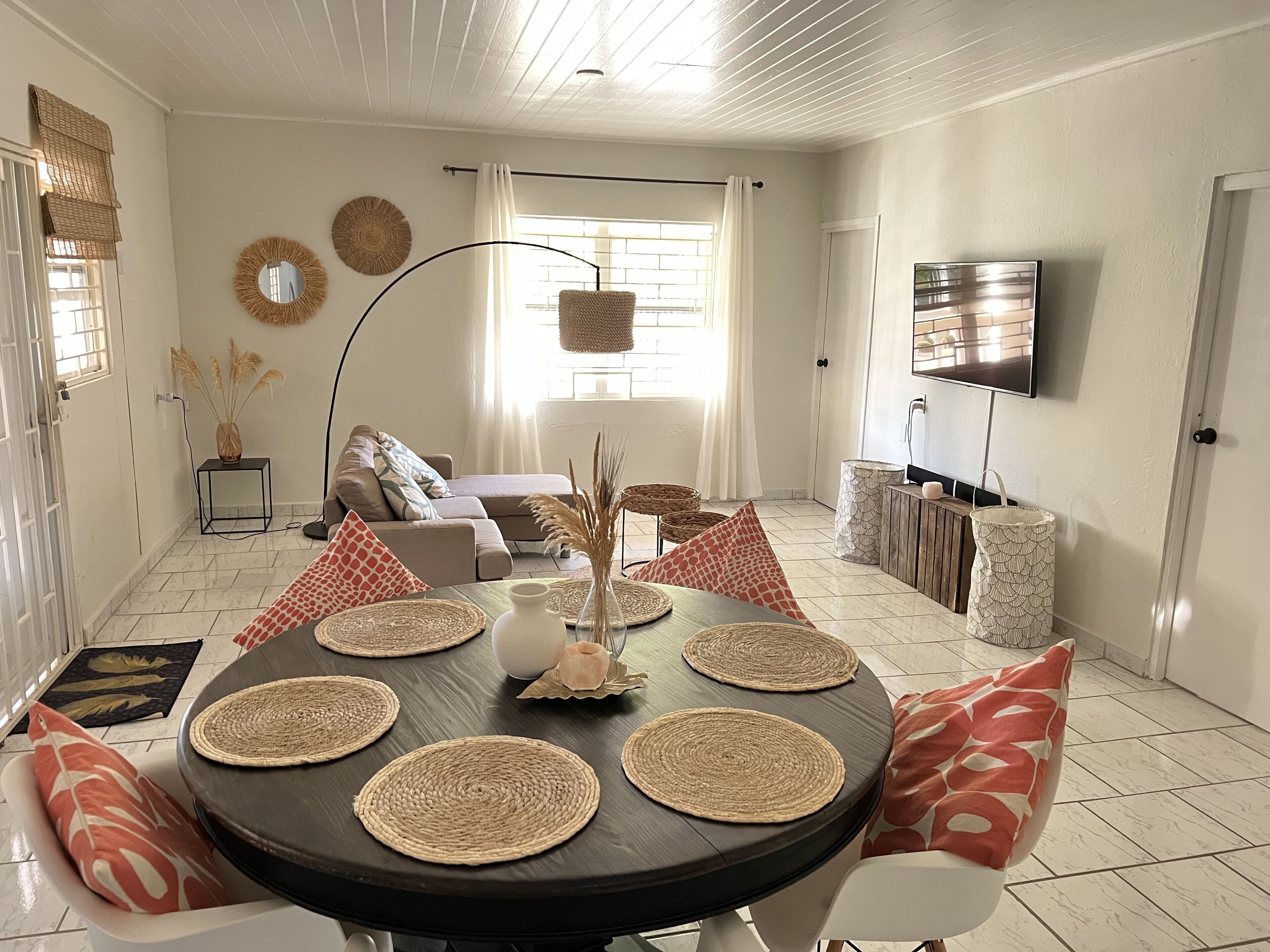 A dining area with a round table, placemats, and chairs.