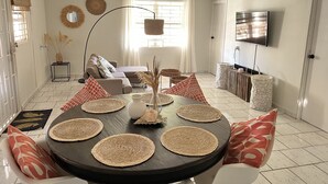 Zona pranzo con tavolo rotondo, sottopiatti e sedie.