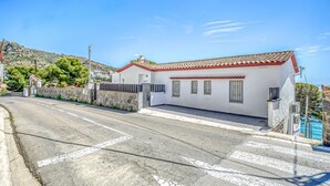 A coastal building with a red-tiled roof, white walls, and a small porch. - ALMADRAVA BEACH 2 Roses (Rosas / Roses)