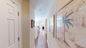 A hallway with a wooden floor, white walls, and a large framed artwork on the right. - Golf Course Oasis Inviting 3BRVilla Pawleys Island (Pawleys Island)