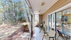 En inglasad veranda med utsikt över ett skogsområde.