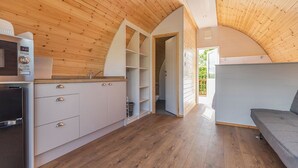 A compact kitchen with modern appliances, a built-in oven, and a wooden ceiling. - High Farm Deluxe Pod (Pet) (Beverley)