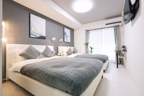 A modern hotel room with two beds, a flat-screen TV mounted on the wall, and a large window with curtains. - Dotonbori Royal (Osaka)
