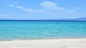 A beach with clear turquoise water and a clear sky. - Stay at Beachfront Villa Lilia in Pefkohori, Halkidiki for a Dreamy Vacation (Kassandra)